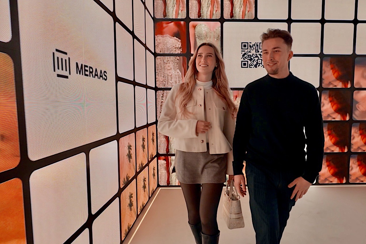 A couple walking through an immersive LED cube at a brand activation