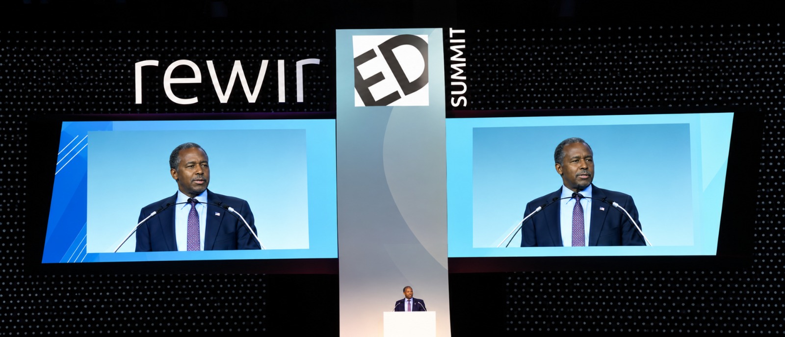 The keynote at the lectern, live on both RewirED screens